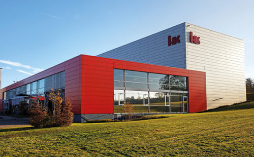 Firmengebäude der Firma Heckler & Koch bestehend aus einem roten und einem silberfarbenen Kubus