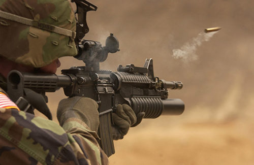 Eine Patronenhülse fliegt aus einen Militärgewehr eines Soldaten