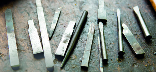 Werkzeuge eines Büchsenmachers liegen auf einer alten Werkbank